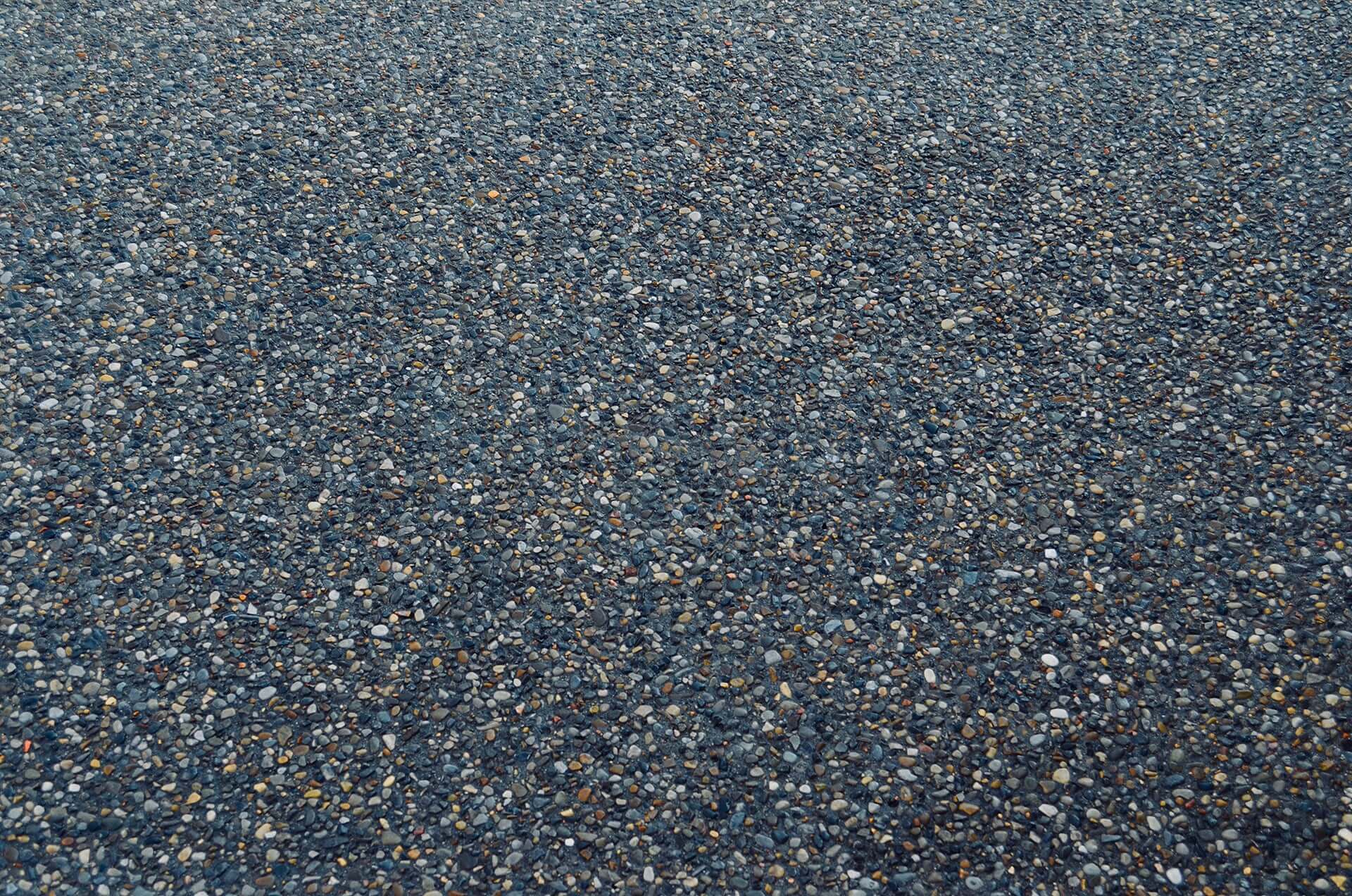 black dyed exposed aggregate is shown in a macro view highlighting the beautiful consistency of 10mm rock.