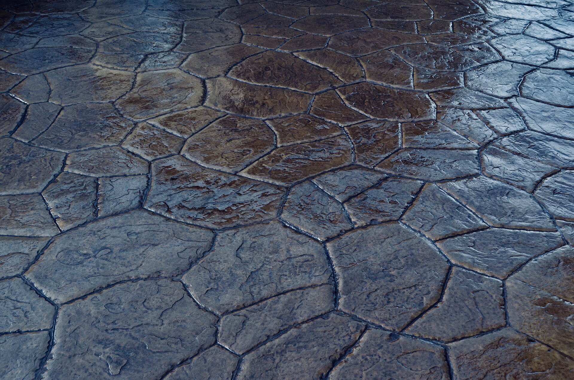 a palate of browns shine through on a freshly sealed stamped concrete patio. The pattern is Sante Fe Stone.