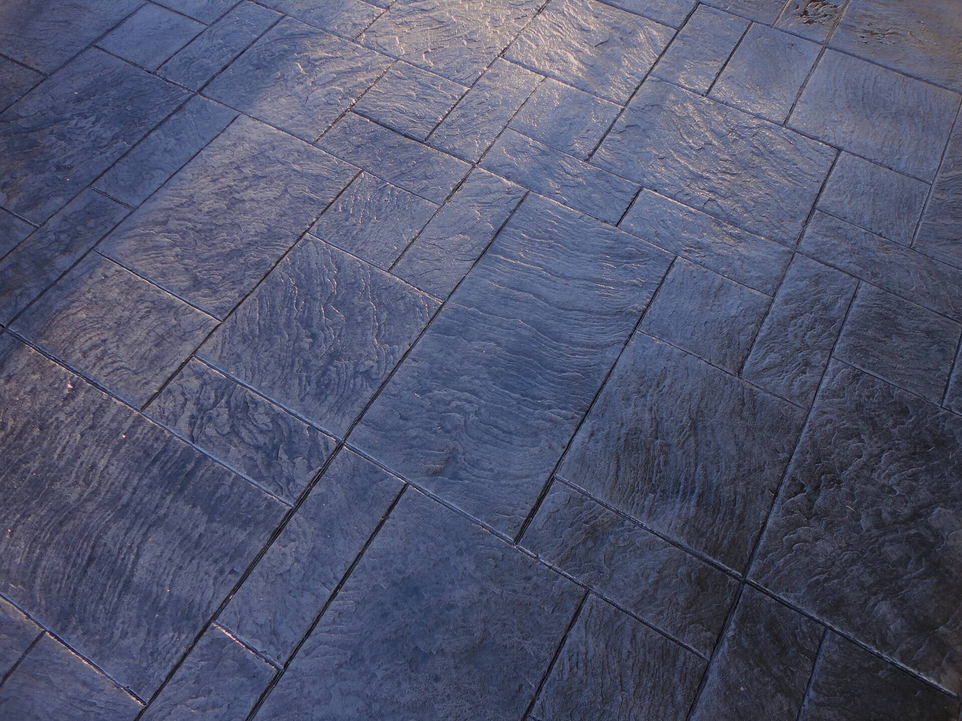 a Royal Ashlar patterned stamped concrete patio finished in shades of greys and charcoals.
